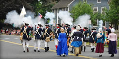 Revolutionary War reenactors fire their rifles.